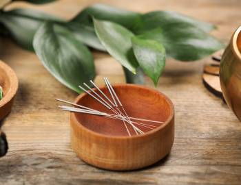 acupuncture needles in wooden bowl in spa