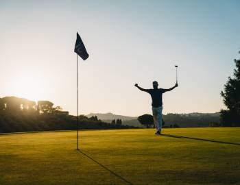 man on golf course celebrating after making shot
