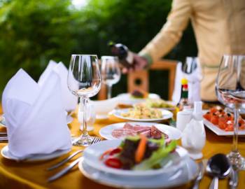 waiter pouring wine at a table