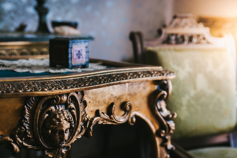 antique desk close up with vintage chair in background