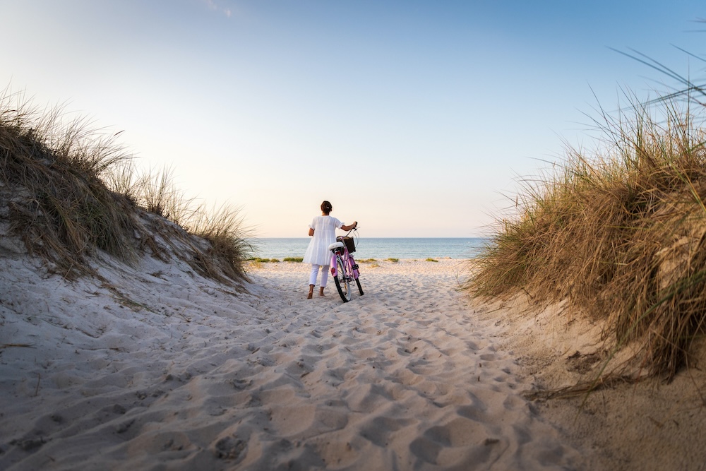 woman on beach with bike