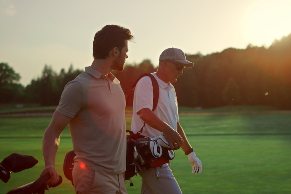 two men walking on golf course